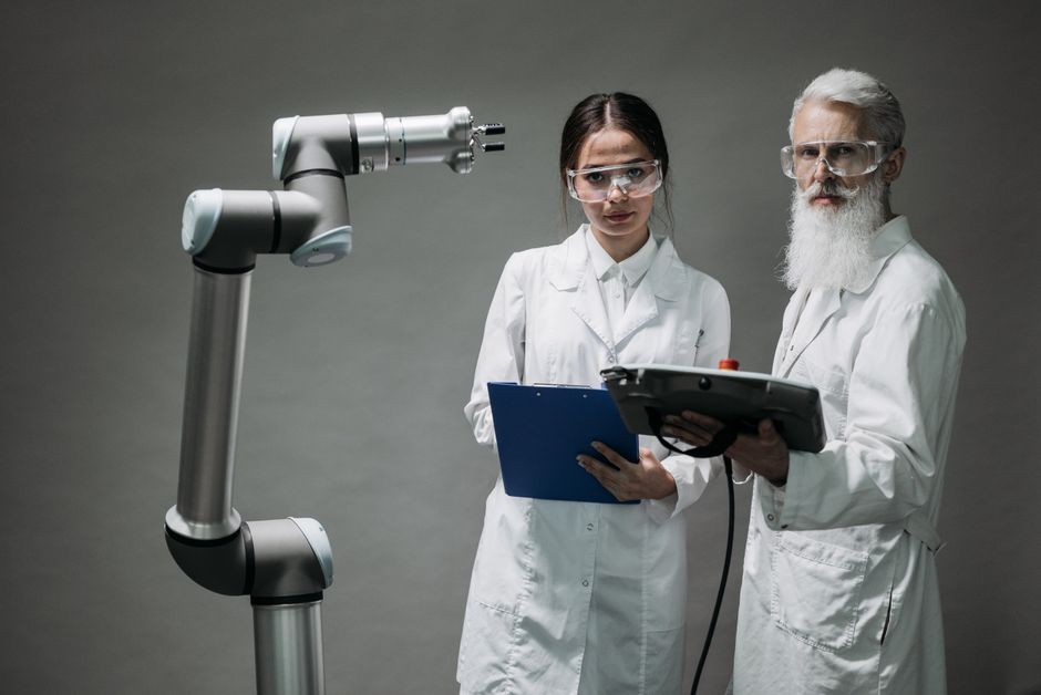 Dva stručnjaka analiziraju robotsku ruku u laboratoriju